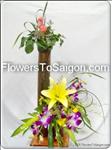 This arrangement of seasonal colors will brighten a room. Pink roses, purple orchid, a yellow lily  arranged with greens and accents in a unique vase - A striking bouquet appropriate for any occasion. 
