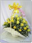 Two dozen yellow roses are beautifully arranged with greens in a basket. It’s a real delight for whomever receives it.
