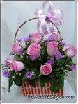 Someone will be charmed by this gift of 12 hot pink roses in a handled basket, surrounded by assorted greenery.